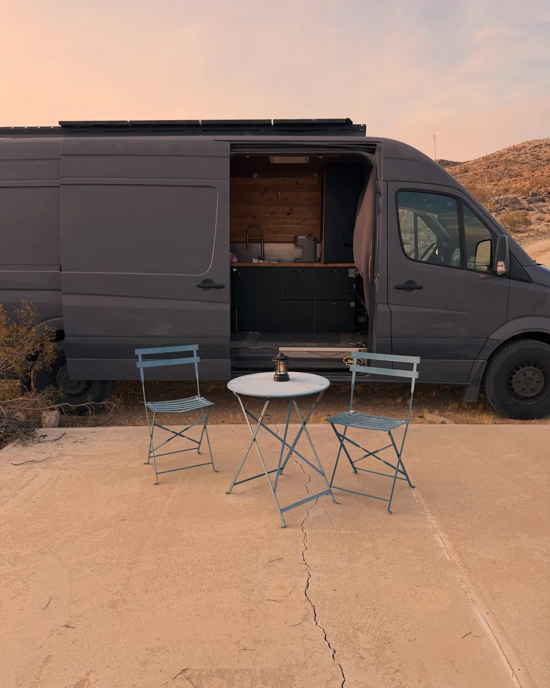 Sprinter van and bistro table at a Moon Rock Ranch campsite